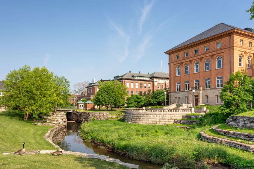 A view of the Illinois State University campus showing a flowing creek, Canadian geese, and lush grass and trees. Illinois State University offers a fully funded Master's in Social Work.