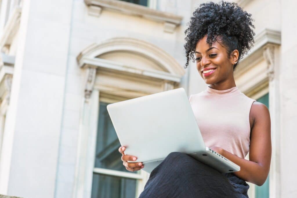 woman holding a laptop computer and smiling