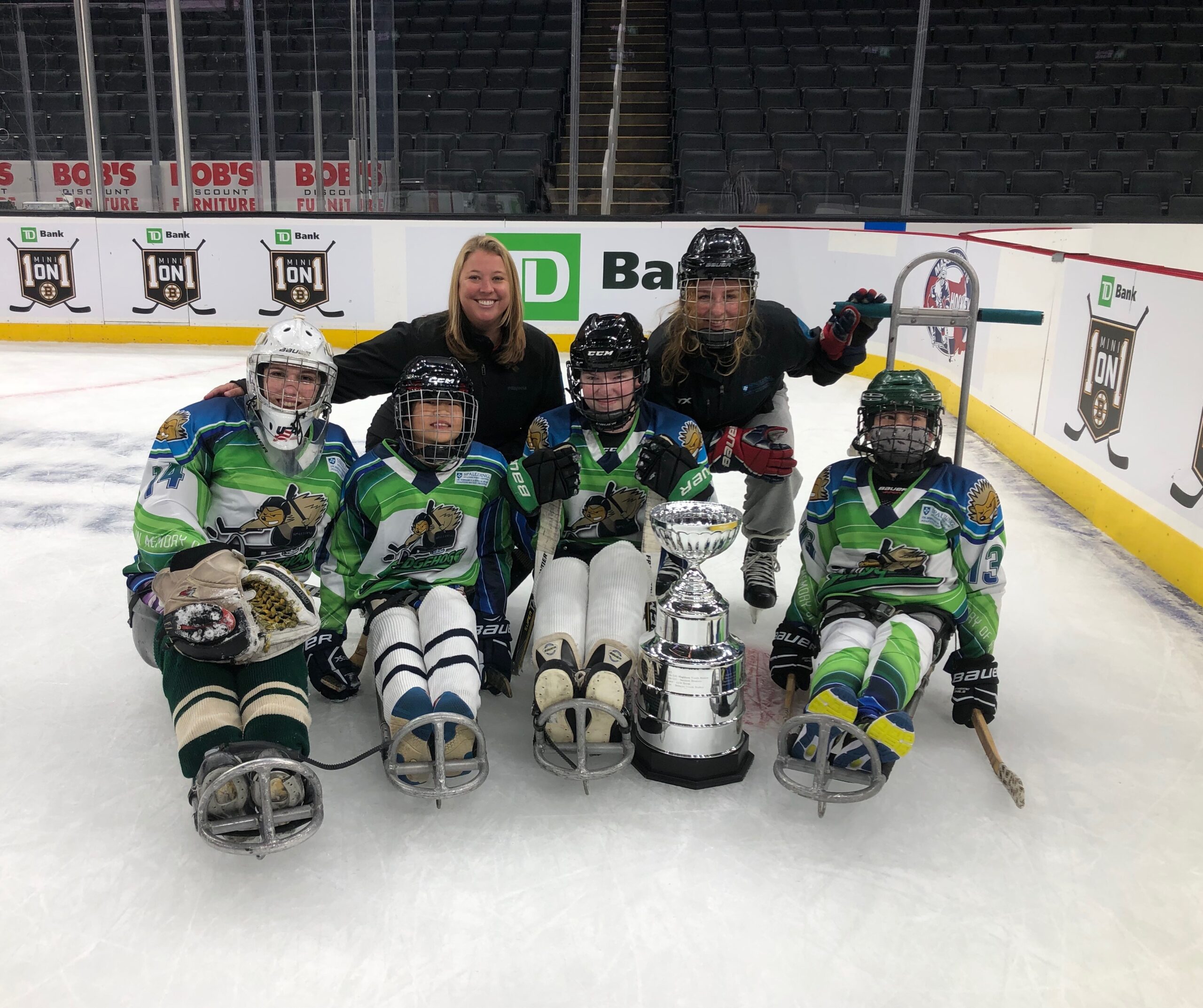 Madeline Cushing and hockey team in gear on ice skating rink 