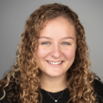 Madeline Cushing headshot black shirt and grey background