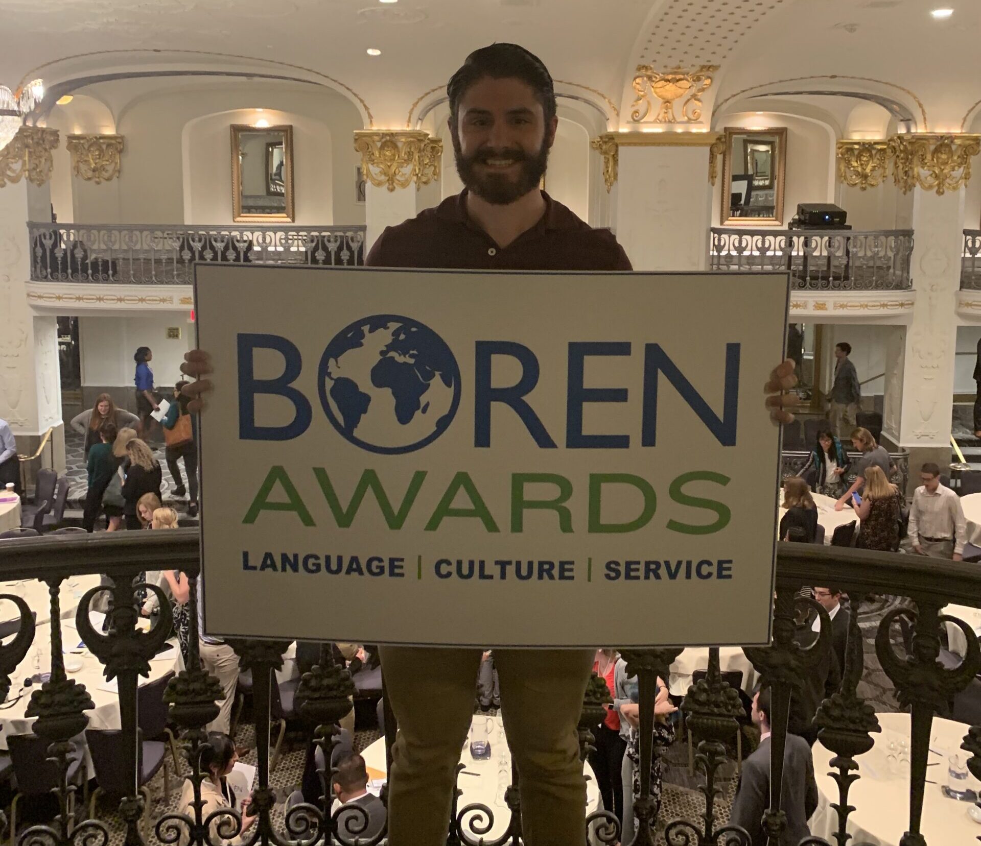Nicholas Mancini holding the Boren Awards sign. 