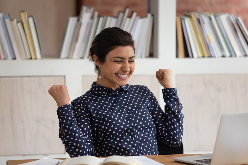 A young woman of Indian ethnicity is elated that she has been accepted to her graduate school of choice.