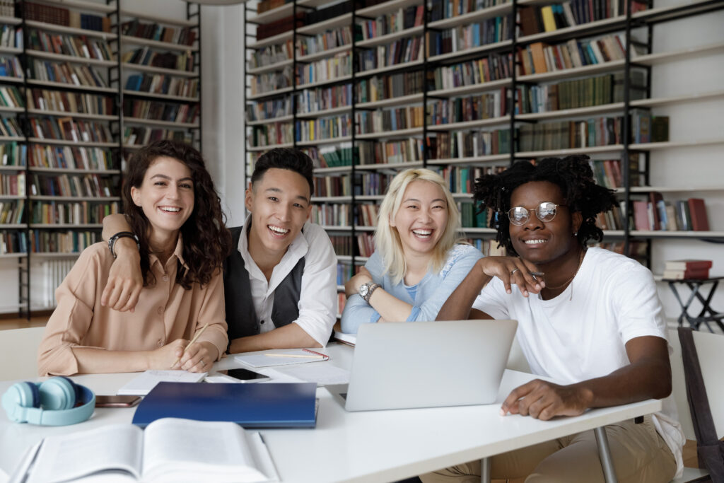 Happy positive diverse university students studying and discussing what they want to do after graduation.