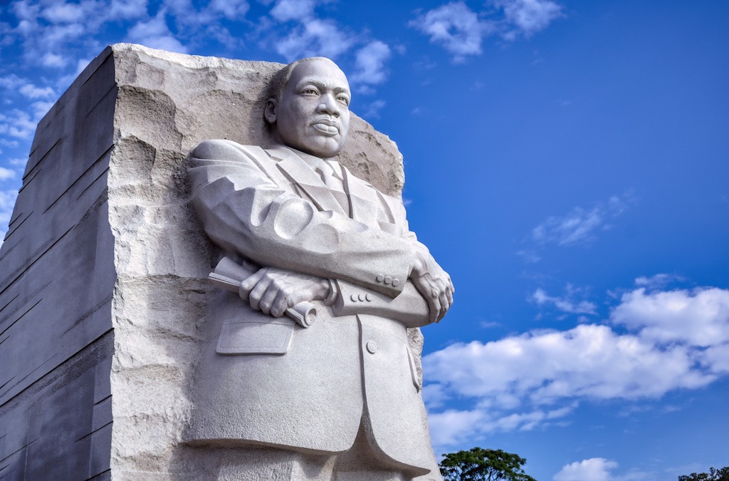 A picture of the Dr. Martin Luther King Memorial statue in Washington, D.C. on a beautiful day with a bright blue sky smattered with wispy clouds.