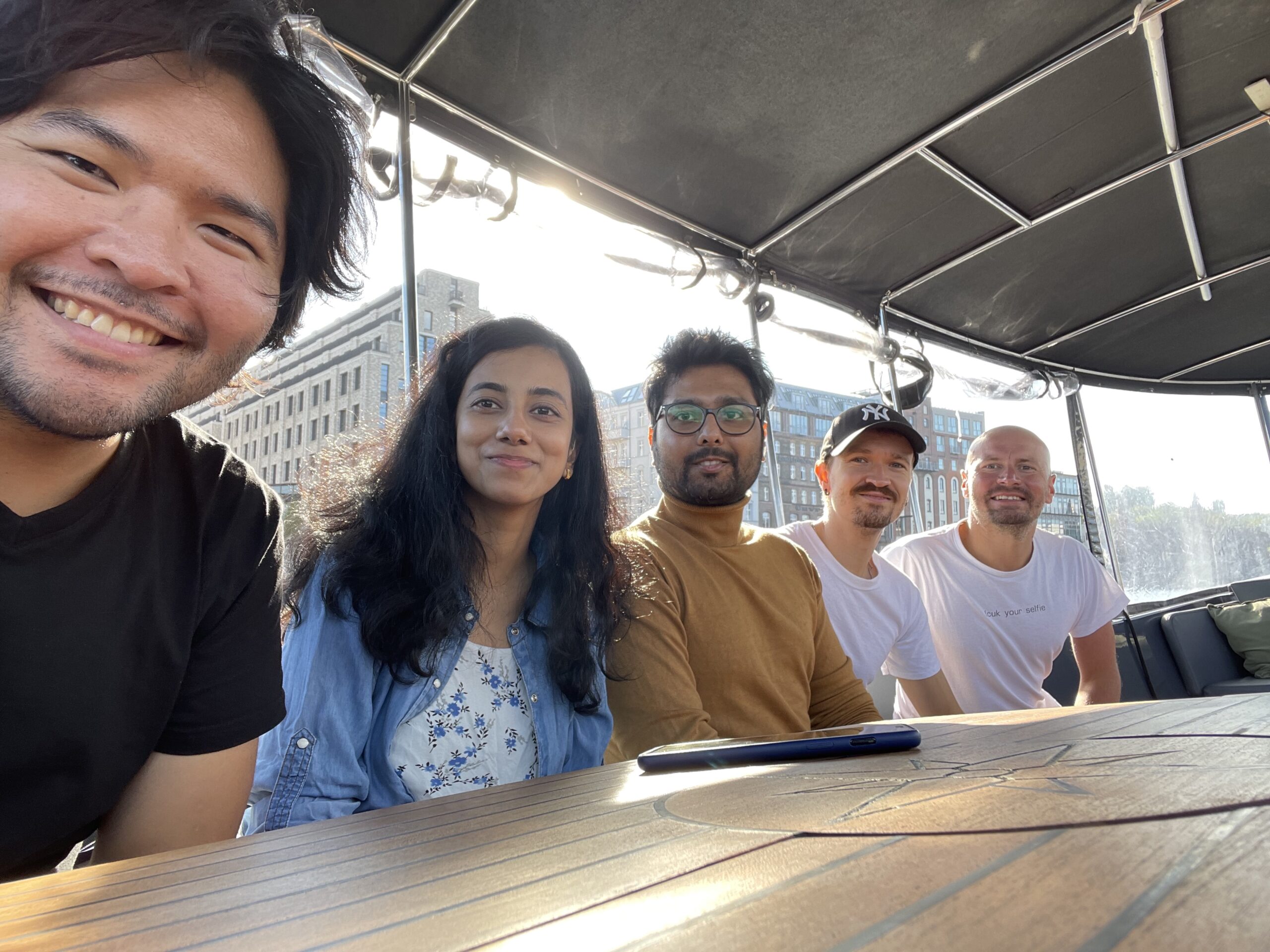 Tyler Pugeda smiling with his cohort of 2022 Fulbright Germany Fellows on a boat tour of Berlin, Germany with Indian Expats and Native Deaf Germans.