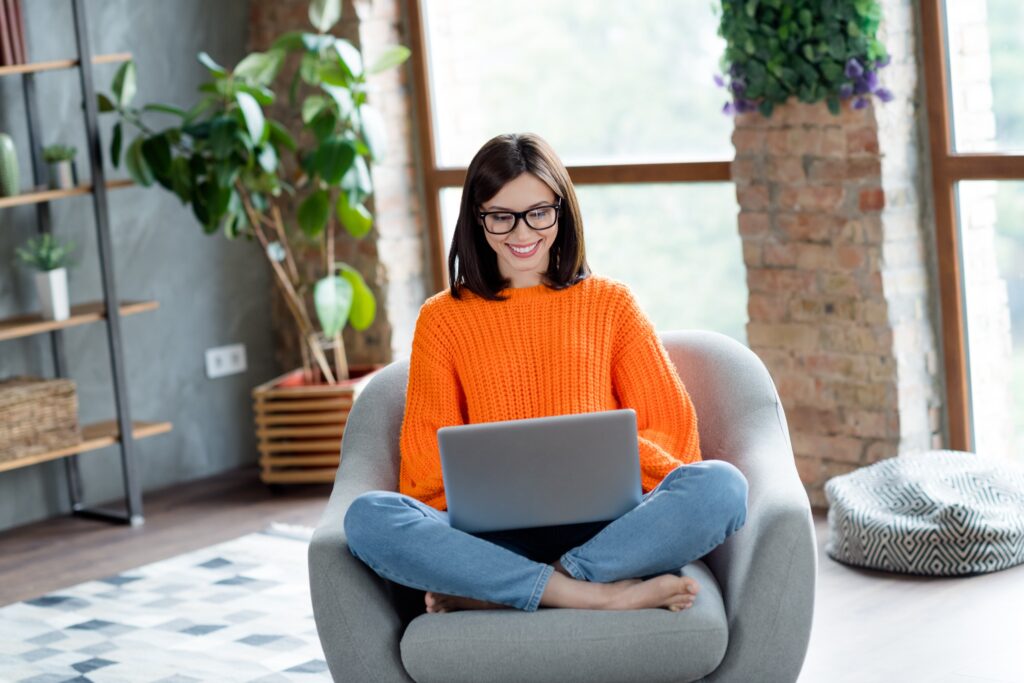 Joyful positive university student sitting in a comfortable chair writing job applications