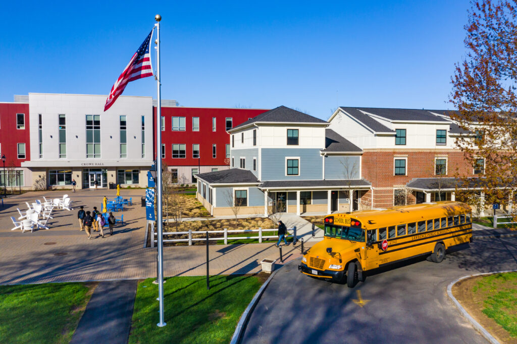 Outside shot of a school with a school bus in front.