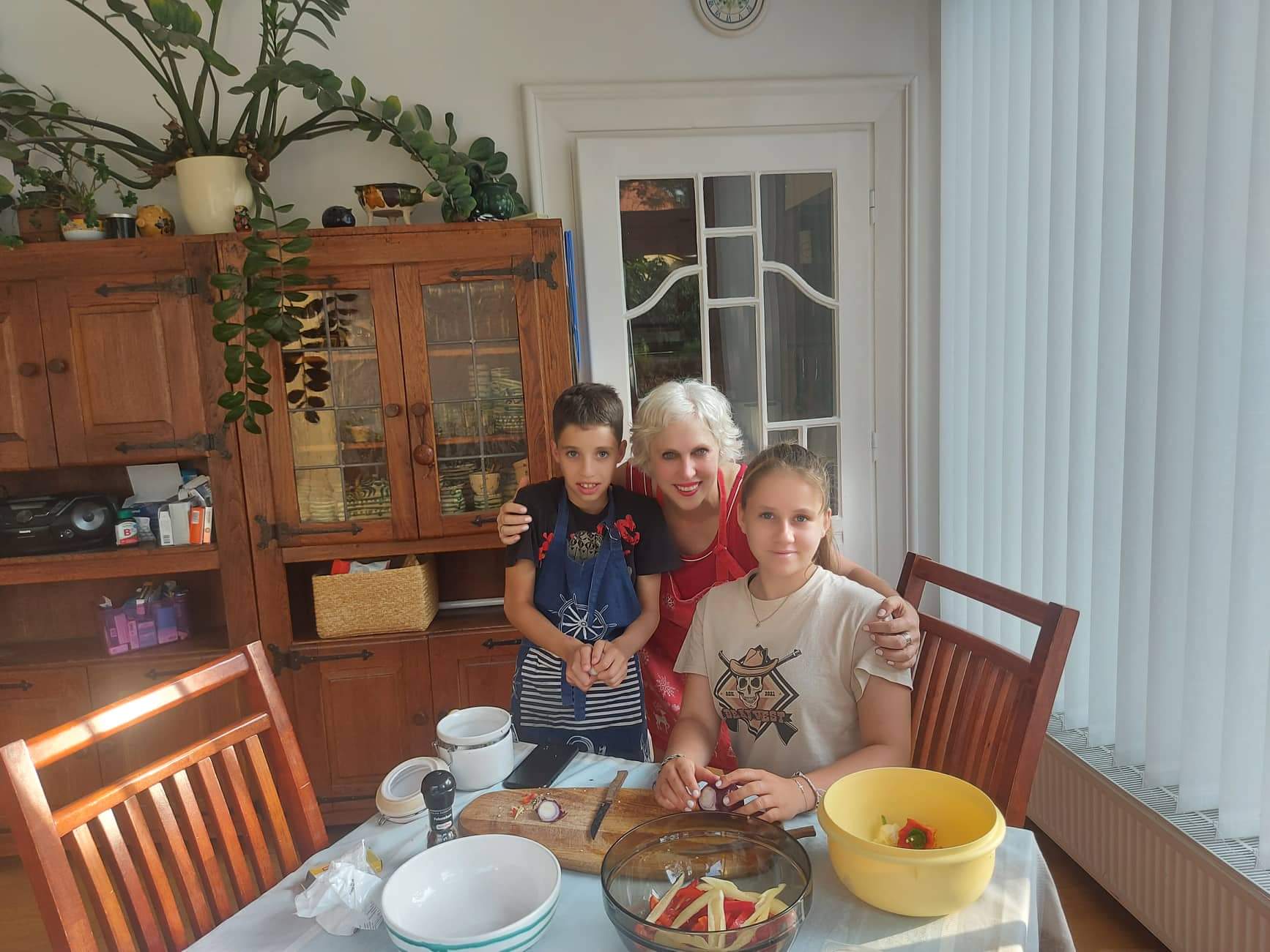 Kelli Buzzard, Budapest Fellow, posing for a picture with a Hungarian family by their dinner table at their home.