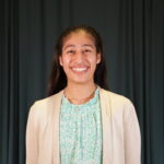 Magaly Cabrera-Ortiz Headshot wearing green blouse and light brown cardigan.