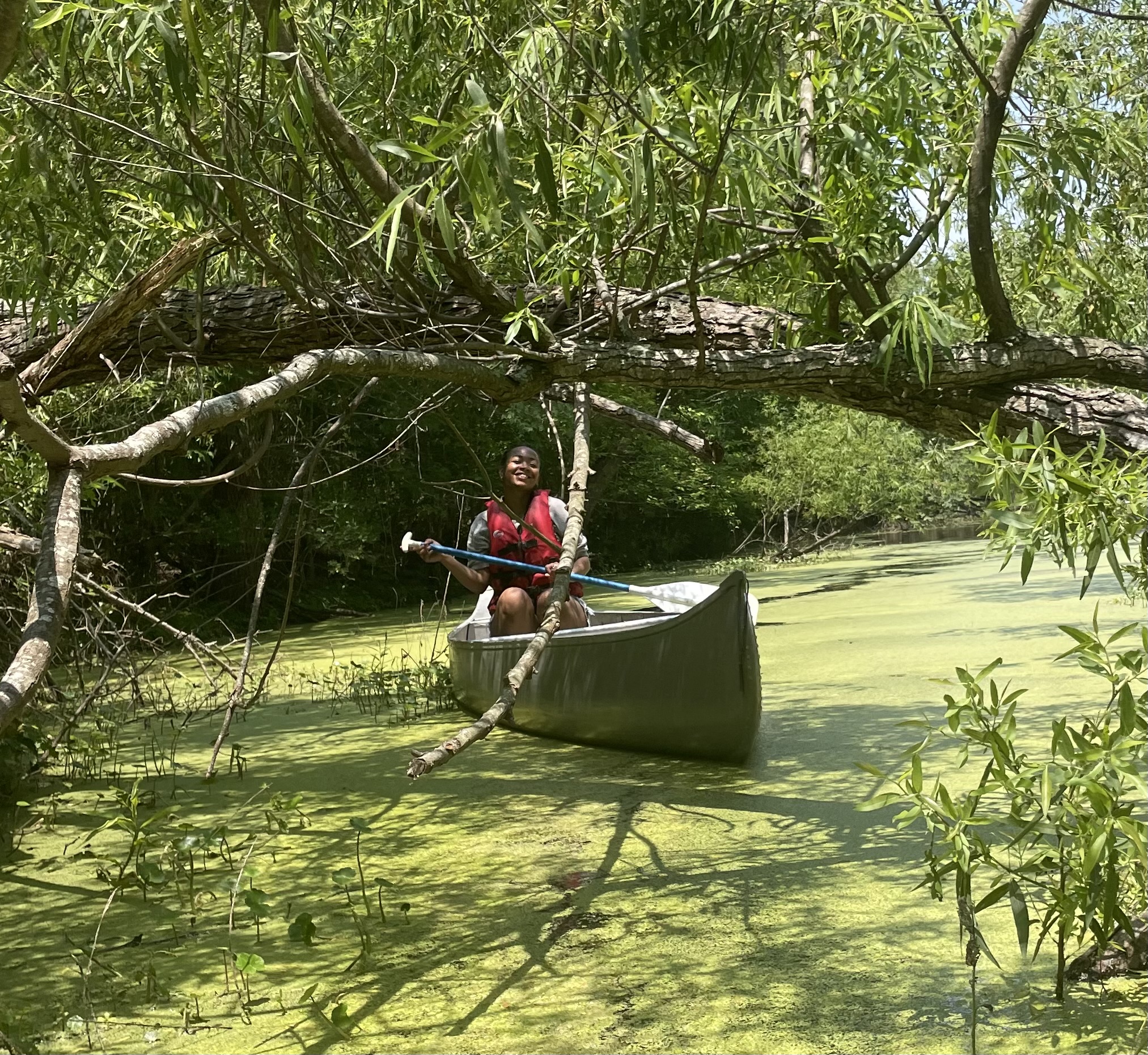 At AmeriCorps VISTA appreciation day Juanita smiles as she rows a canoe.