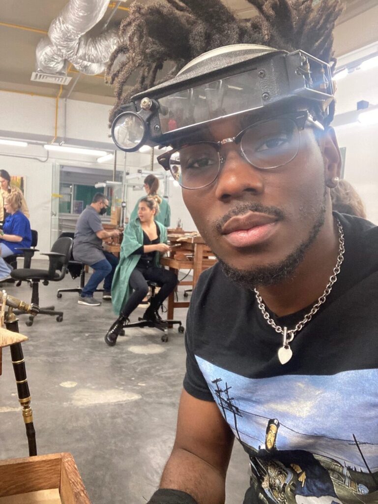 Jonathan Blackmon sitting at a jeweler's bench working in silver in São Paulo, Brazil during his Boren Fellowship (an intensive language study fellowship).