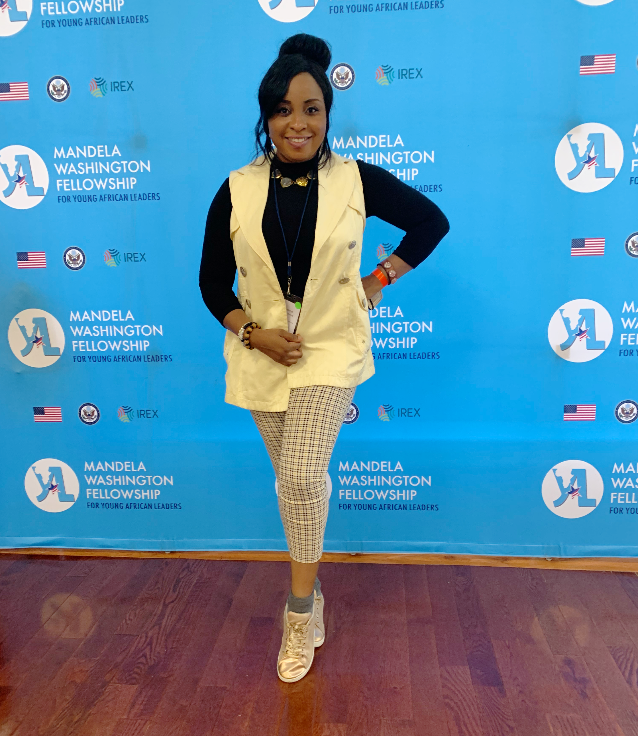Racheal Inegbedion posing in front of a blue banner that reads The Mandela Washington Fellowship.