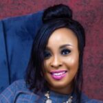 Headshot image of Racheal Inegbedion sitting on a blue couch