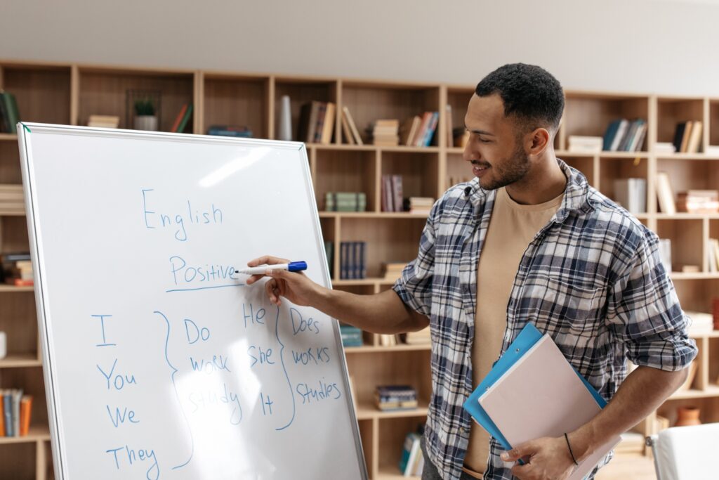 Cheerful Arab male teaching English to elementary age students while on a Fulbright English Teaching Assistantship Award.
