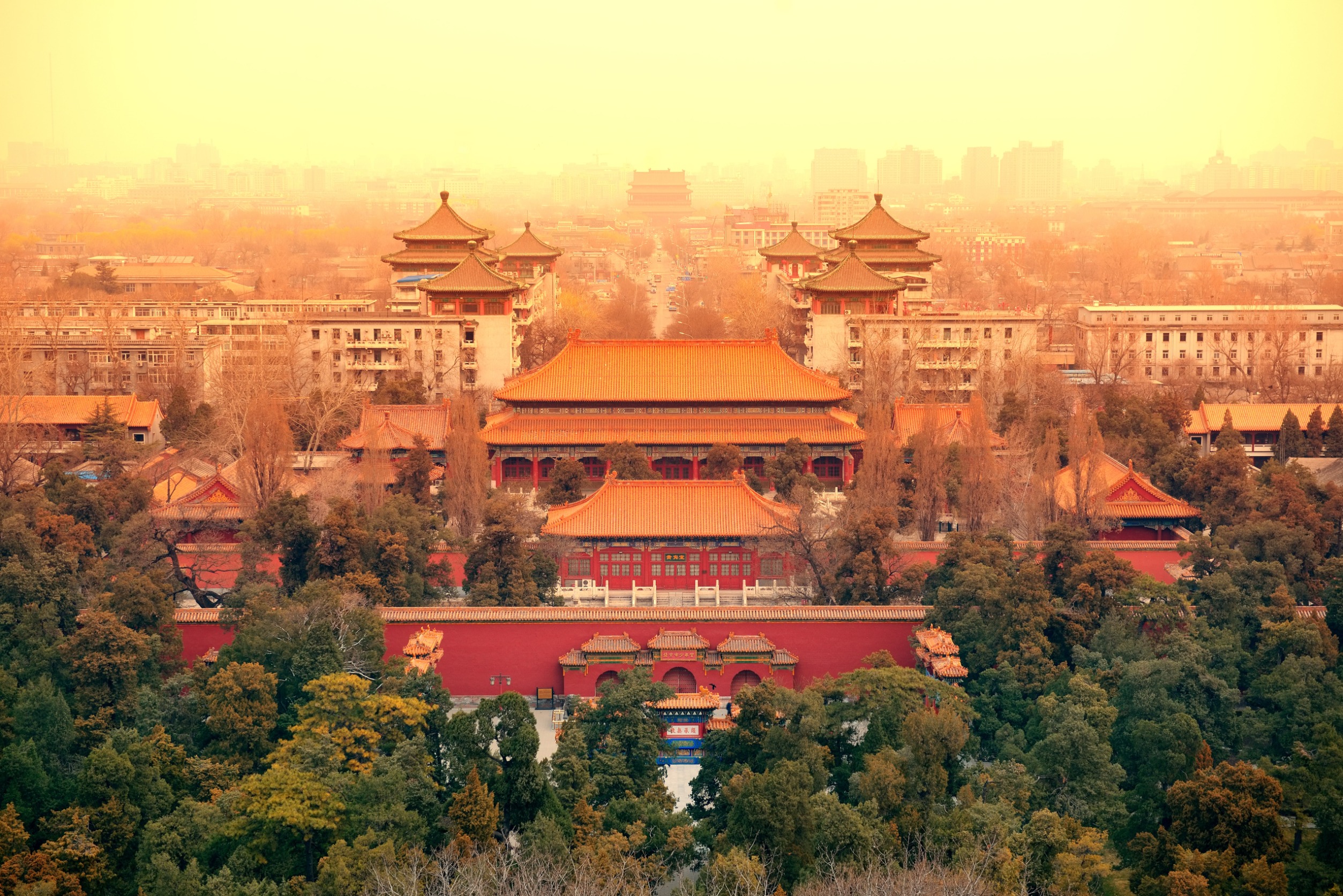 Aerial view of Beijing, China at dusk with historical Chinese architecture.