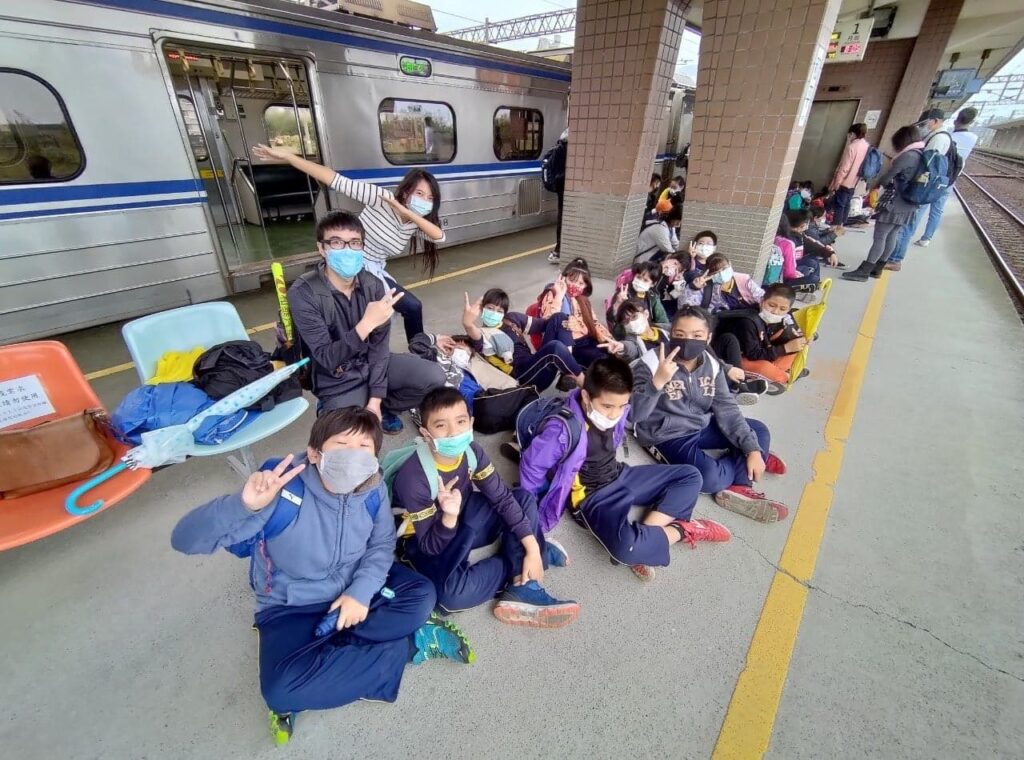 Fulbright ETA in Taiwan Sunny Huang posing for a picture with her fourth grade students outside of a train after taking the train while on a field trip to Yilan County, Taiwan to learn about environmental science and soy products.