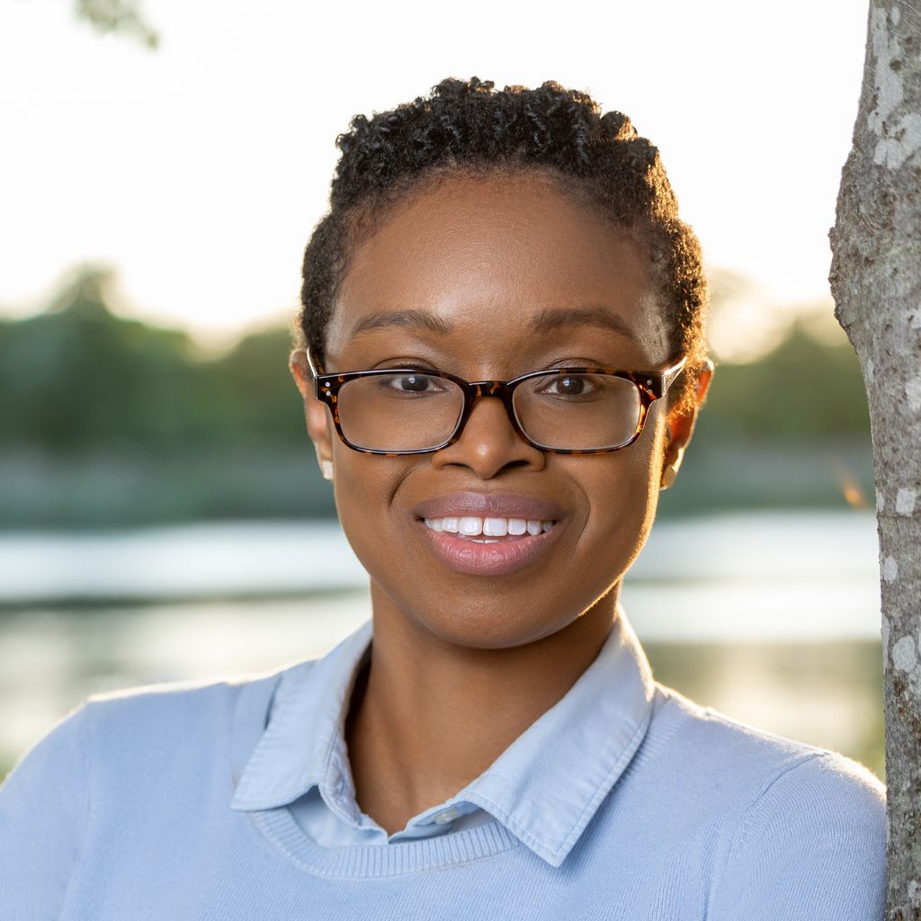 Professional photo of Dr. Ayanna Vasquez leaning against a tree in front of a serine lake surrounded by trees. Dr. Vasquez is the recipient of a fully funded preventive medicine residency, which includes an option to pursue a fully funded MPH, at the University of Wisconsin-Madison.