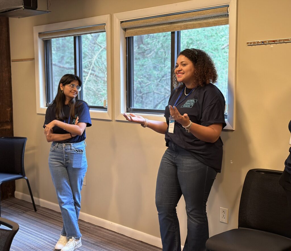 Paris at the Global Health Corps U.S. Fellowship retreat, standing by windows, talking with fellow GHC cohort members.