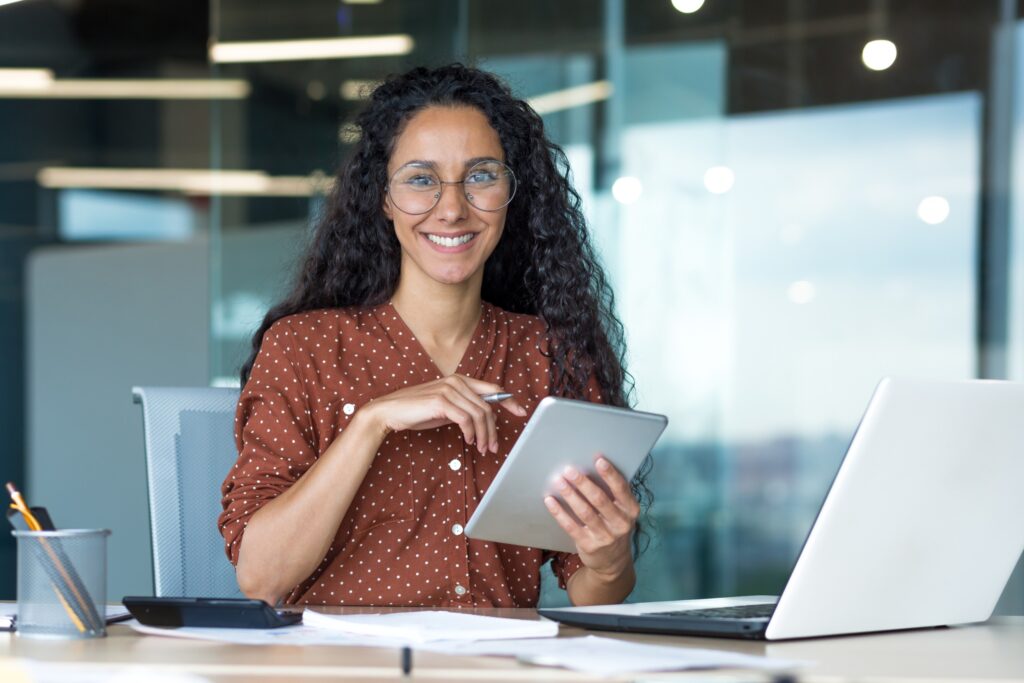 Happy and successful Hispanic woman working inside modern office building