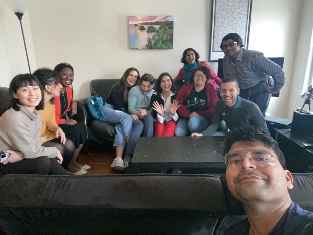 Dr. Mohan took a selfie surrounded by several other Fulbright scholars. They sit on black couches and are of various ethnicities.