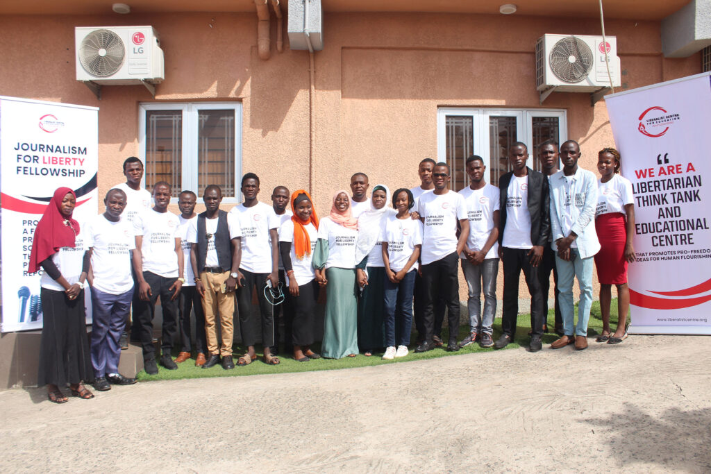 Favour Adeboye and her cohort stand outside smiling in front of Journalism for Liberty banners.