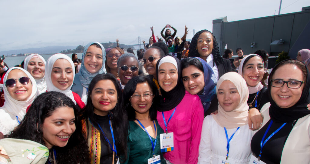 TechWomen Fellowship winner Amanda Obidike along with other fellows taking a group picture. The people consists of multicultural women, some wearing hijab.