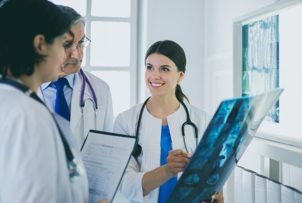 Smiling doctors discussing patients diagnosis looking at x-rays in a hospital. This image is representative of upcoming fellowship deadlines for physician assistant programs.